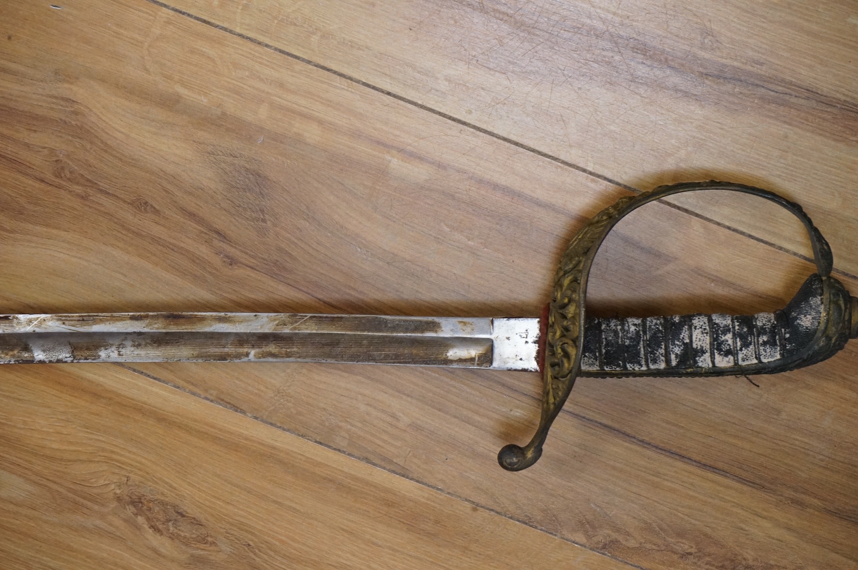 An officer’s sword, three walking sticks and an antique sword stick, longest walking stick 92cm long